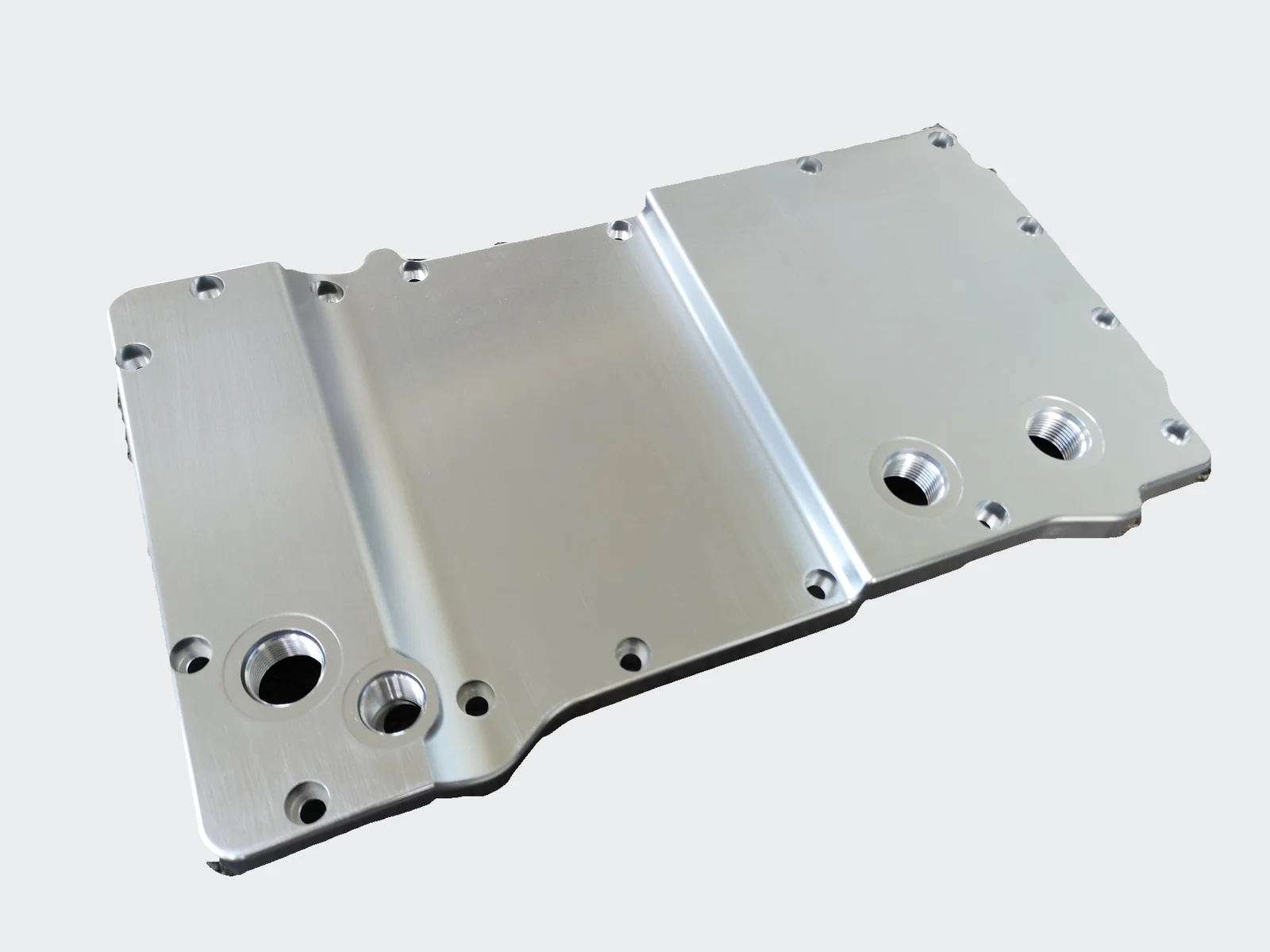 Opposite face of the machined oil pan showing its shallow profile and threaded ports