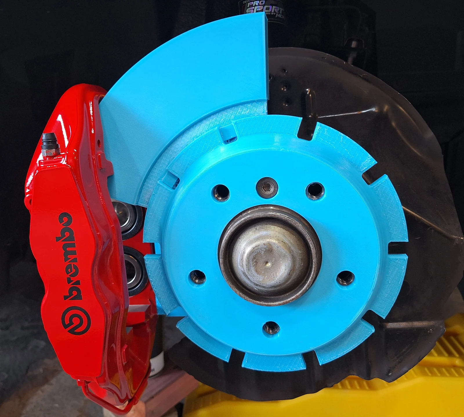 Blue printed brake mock-up fitted beside a red caliper